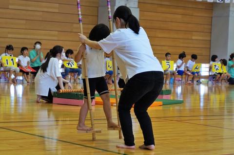 竹馬に挑戦する子どもを支えています