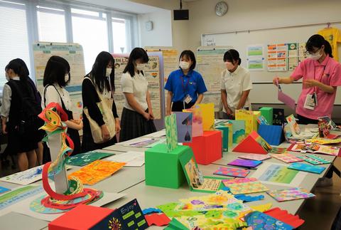 学生の作品に見入る参加者