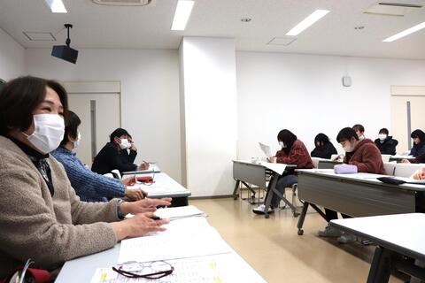 学生の意見に耳を傾けながら答える教員